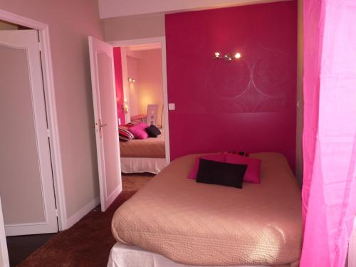 a bedroom with purple walls and a bed in it at Hôtel Patton in Avranches