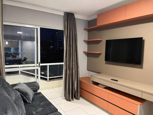 a living room with a tv and a couch at Apto 33 - Completo no Centro de Foz in Foz do Iguaçu
