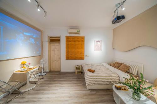 a bedroom with a bed and a large screen at Aimee House Vũ Miên in Hanoi