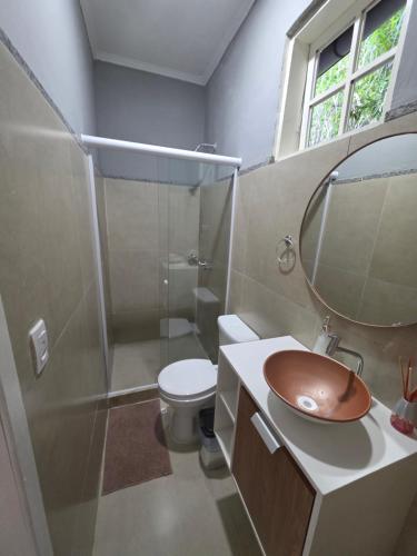 a bathroom with a sink and a toilet and a mirror at Sitio Mangalarga in Araras Petropolis