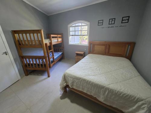 a bedroom with a bed and two chairs and a window at Sitio Mangalarga in Araras Petropolis