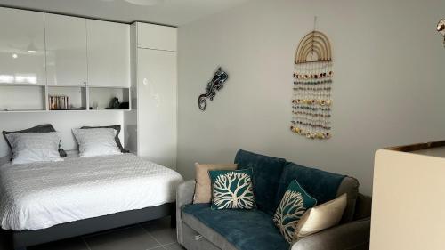 a living room with a bed and a couch at Rêve Marina studio tout confort avec citerne et piscine Gosier in Pointe-à-Pitre
