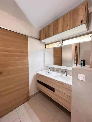 a bathroom with two sinks and a mirror at Rêve Marina studio tout confort avec citerne et piscine Gosier in Pointe-à-Pitre