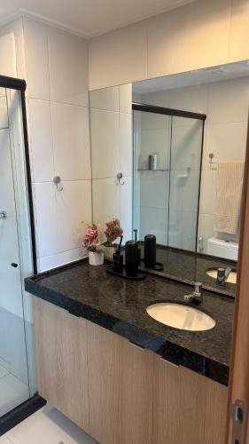 a bathroom with a sink and a large mirror at Flat Inteiro no Makia Beach Experience in Porto De Galinhas