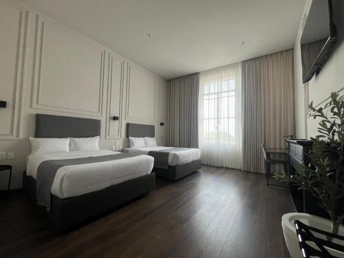a hotel room with two beds and a tv at Vista Catedral Guadalajara - Self Check in in Guadalajara
