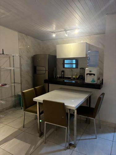 a kitchen with a table and chairs in a kitchen at Casa Completa Proximo ao Frances in Marechal Deodoro