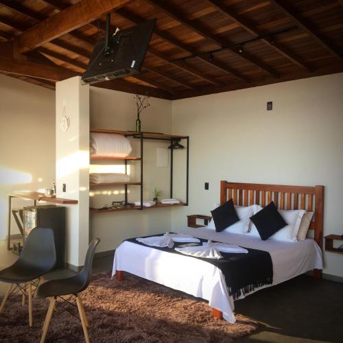 a bedroom with a bed and a table and chairs at Shangri-lá Chalés in Gonçalves