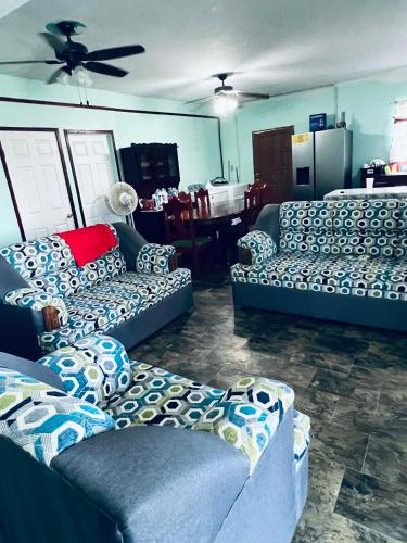 a living room with two couches and a dining room at LAMBS LODGE, RESTURANT & CooL SPOT in Ontario Village
