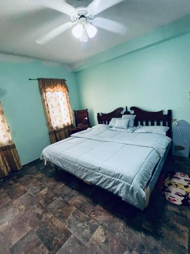 a bedroom with a large bed with a ceiling fan at LAMBS LODGE, RESTURANT & CooL SPOT in Ontario Village