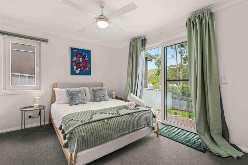 a bedroom with a bed and a large window at Blenheim Breeze by Experience Jervis Bay in Vincentia