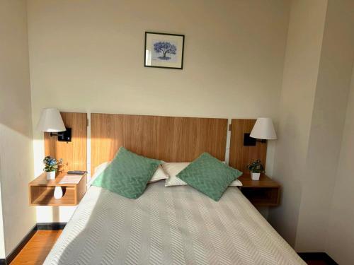 a bedroom with a bed with green pillows at Urban Escape Sky View in Cochabamba
