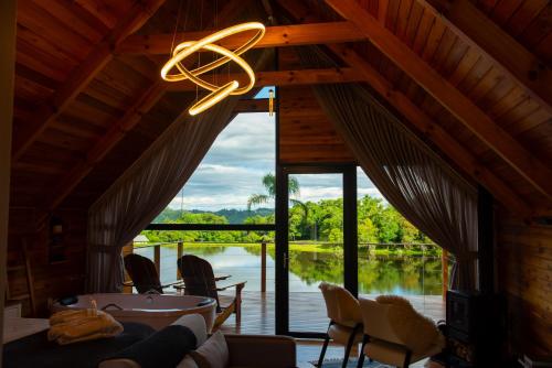 a living room with a view of the water at Cabana Terra - Hidro com vista, Lareira e Café da manhã in Nova Petrópolis