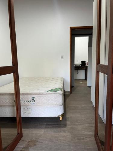 a bedroom with a bed and a hallway with a mirror at Recanto do sossego in Gravataí