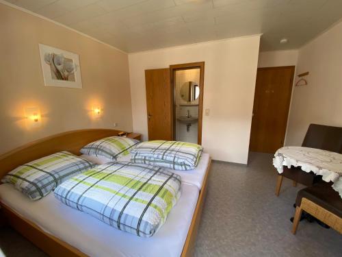 a bedroom with a bed with pillows and a refrigerator at Gästehaus im Oberdorf in Erden