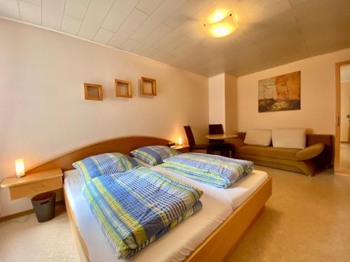 a bedroom with a bed with pillows and a couch at Gästehaus im Oberdorf in Erden