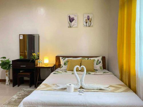 a bedroom with a bed with a swan decoration on it at Golden palm rise resort in Libaong