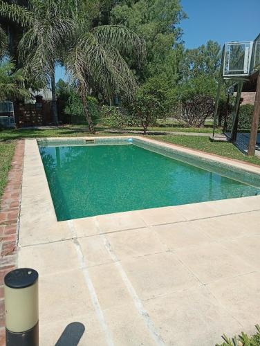a swimming pool in a yard next to a house at Morada de Duendes in Sauce Viejo