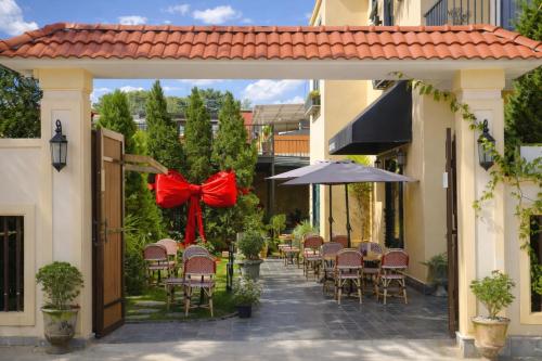 a patio with tables and chairs with a red bow at Hôtel De Da Phu in Da Lat