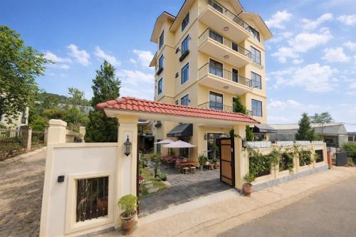 a large yellow building with a patio in front of it at Hôtel De Da Phu in Da Lat