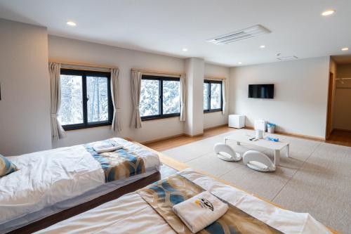 a large bedroom with a large bed and windows at 苗場サンバレーホテル in Minami Uonuma