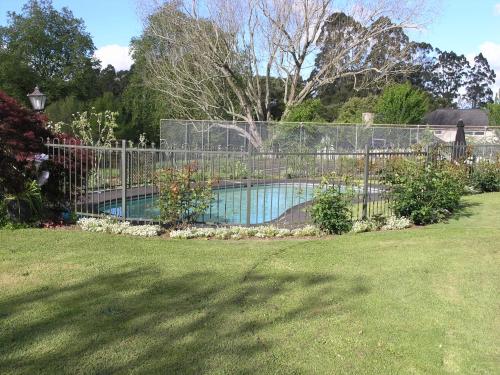 a fence around a swimming pool in a yard at Woodhey Retreat Unit 2 in Karapiro