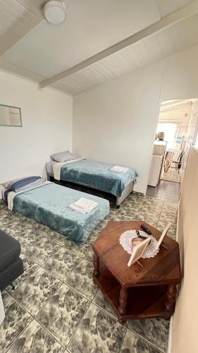 a room with two beds and a coffee table at Estrellas del Sur in Río Gallegos