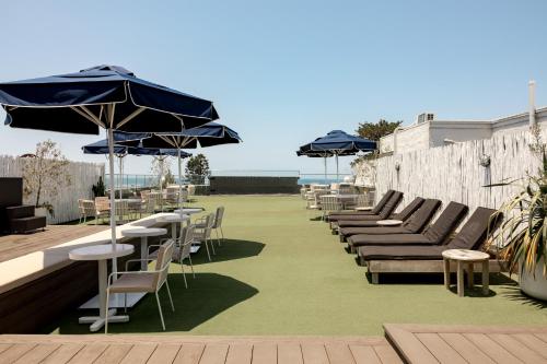 a row of tables and chairs with umbrellas on a patio at Wake Up! Bondi Beach in Sydney