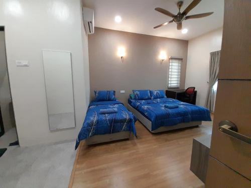 a bedroom with two beds and a ceiling fan at Teratak Assofiyya 4 Bilik in Sungai Petani