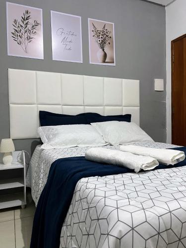 a bedroom with a large bed with a white headboard at Royalties Flats in Petrolina