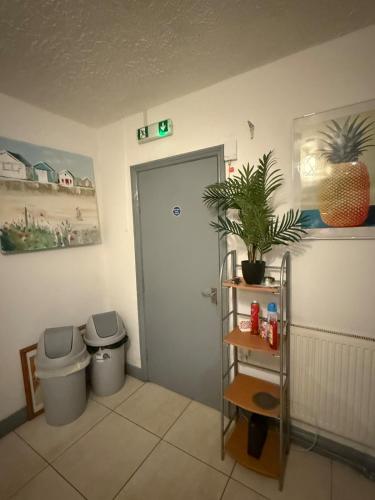a bathroom with two trash cans and a door at Eastern Bridge House in Spinney Hill