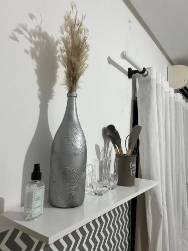 a white shelf with a vase with plants in it at Royalties Flats in Petrolina