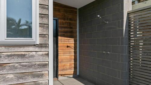 a bathroom with a walk in shower next to a wall at Beach Serenity in Sunderland Bay