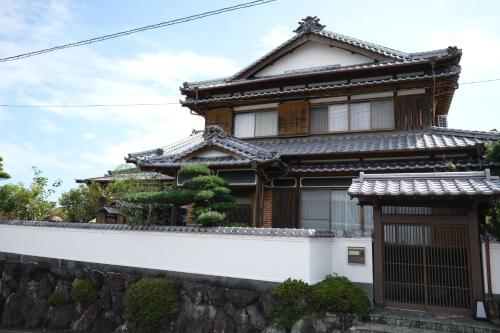 a traditional house with a stone wall at Shimanto Suite by Hideaway in Shimanto