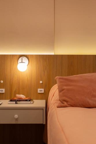 a bedroom with a bed and a nightstand with a lamp at Apt 1012 Conforto aconchego e vibe acolhedora in Santa Maria