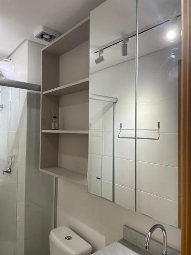 a bathroom with a toilet and a glass shower at Apt 1012 Conforto aconchego e vibe acolhedora in Santa Maria