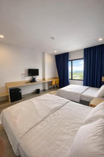 a hotel room with two beds and a television at HT Hotel in Xuyên Mộc