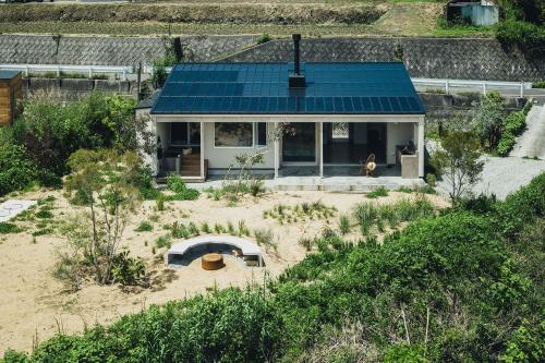 a house with a blue roof with a yard at SANU 2nd Home CURRENT Awajishima in Awaji