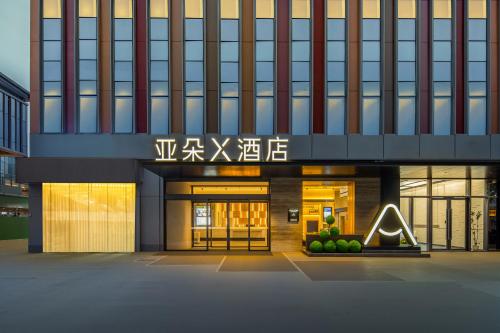 a building with a sign on the front of it at Atour X Hotel Chengdu Qingbaijiang Wanda in Chengdu