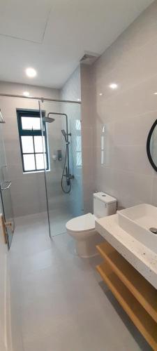 a bathroom with a shower and a toilet and a sink at Villa NovawoRld Phan Thiết in Bình Sum
