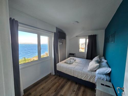 a bedroom with a bed and a large window at Los Dones Departamentos DAT in San Carlos de Bariloche