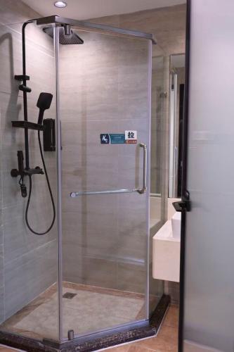 a shower with a glass door in a bathroom at Wave Nest 汐宿 in Chongqing