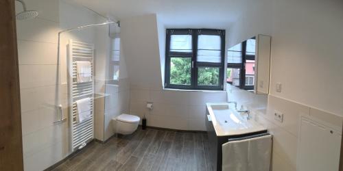 a white bathroom with a sink and a toilet at Boardinghaus Götterhimmel in Obernburg am Main