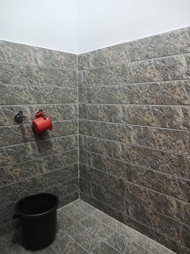 a tiled bathroom with a red extinguisher on the wall at Independent homestay DDN in Dehradun