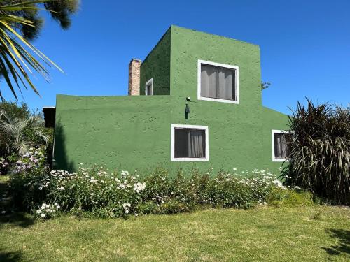 a green house with a window on the side of it at Carranca TH5 in Costa Azul