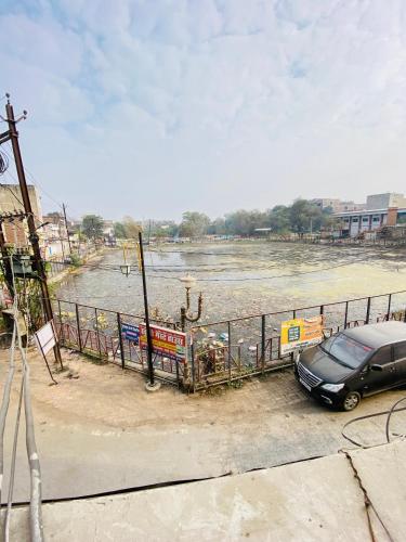 a car parked next to a fence next to a river at The star inn in Ambikāpur