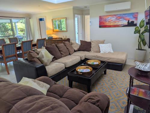 a living room with a couch and a table at Rainforest Cottage in Port Macquarie