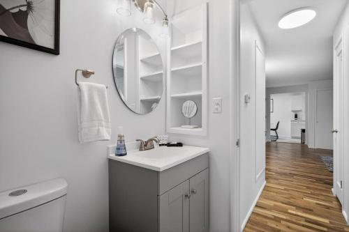 a white bathroom with a sink and a mirror at King Bed 1BDR Stadium District in Tacoma