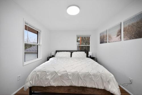 a white bedroom with a bed and two windows at King Bed 1BDR Stadium District in Tacoma