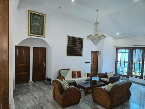 a living room with a couch and chairs and a table at Kuca Cigadung in Bandung