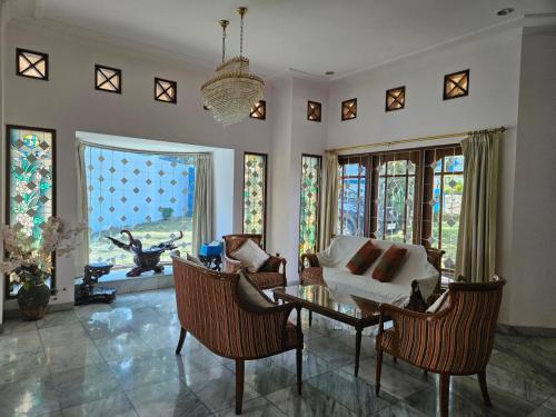 a living room with a couch and chairs and a table at Kuca Cigadung in Bandung